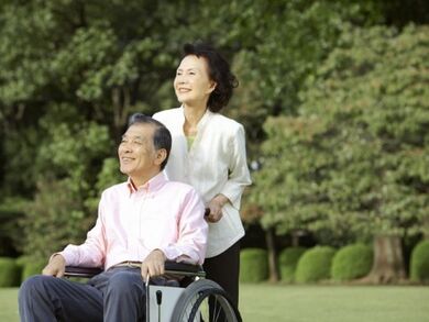 車いすに座っている男性とそれを押している女性。自然豊かな場所で写した写真